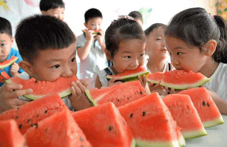 Chinese children eating melon